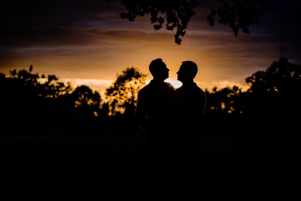 Silhouette of two grooms at their wedding - norfolk wedding photographer